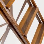 Peldaños estriados de una escalera decorativa de madera de haya en acabado nogal, con su celosía de listones