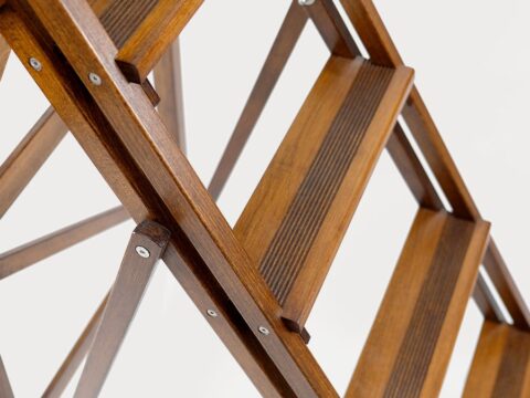 Peldaños estriados de una escalera decorativa de madera de haya en acabado nogal, con su celosía de listones