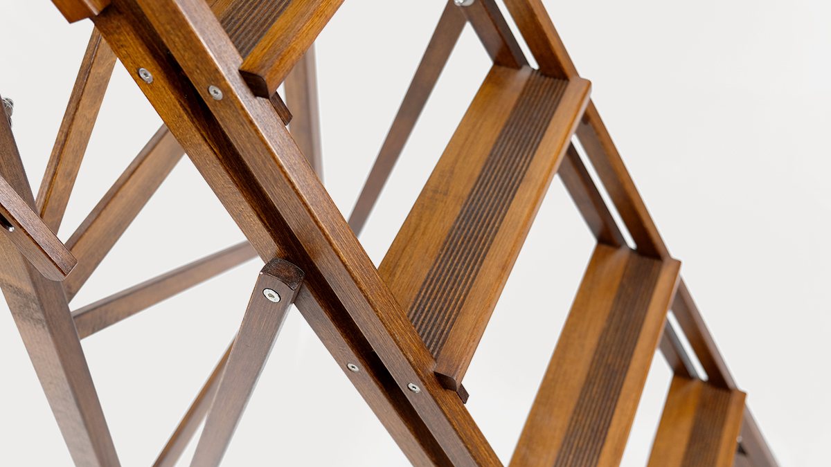 Peldaños estriados de una escalera decorativa de madera de haya en acabado nogal, con su celosía de listones